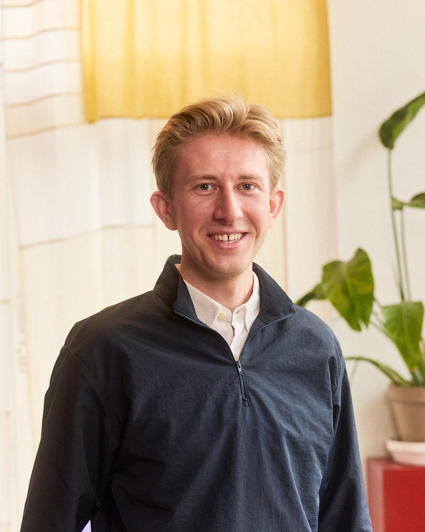 Christian Toft Bach foran et vævet tekstil i gul og sand
