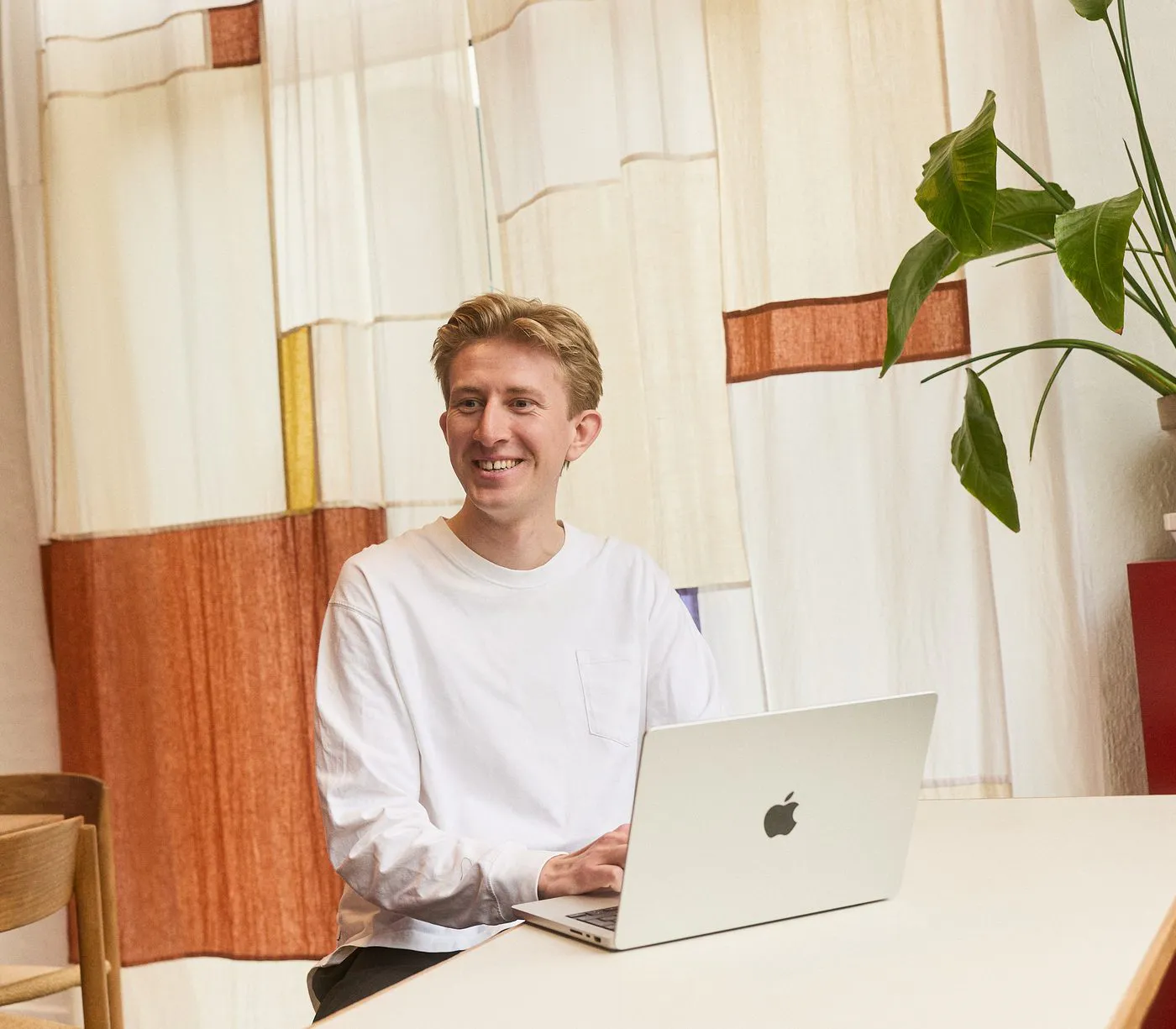Christian Toft Bach ved arbejdsbordet foran et vævet tekstil